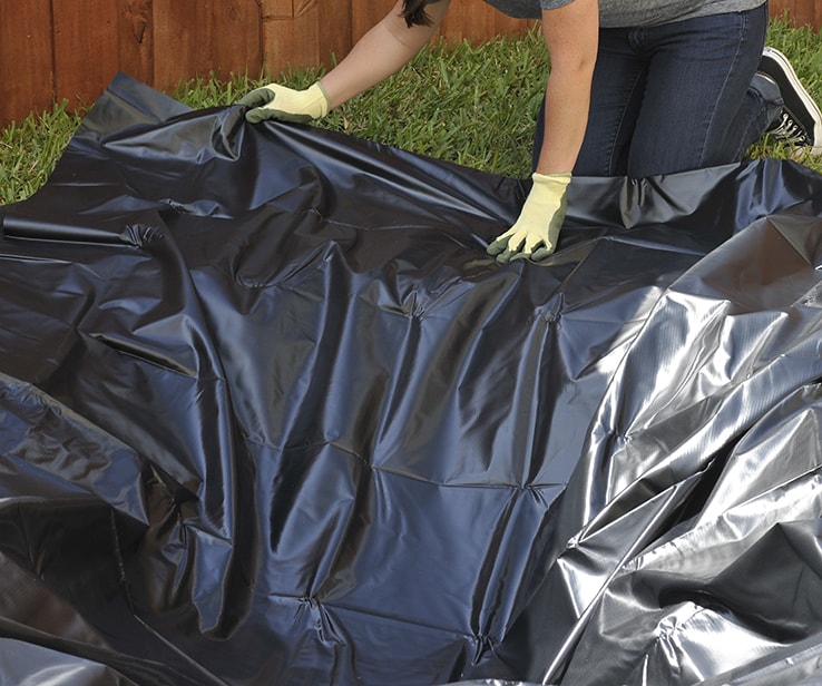 Femme plaçant une toile imperméable dans le fond d’un bassin