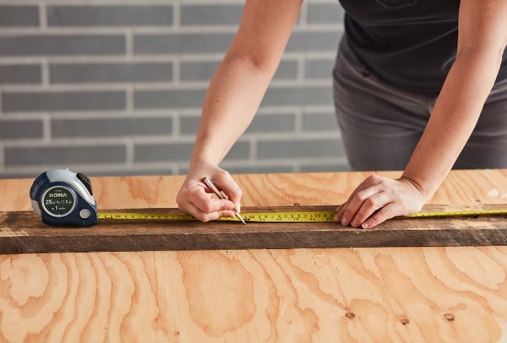 Person measuring a wooden plank