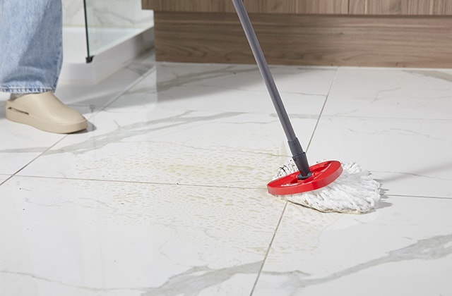 Person mopping a bathroom floor