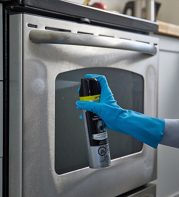 Person cleaning a stainless-steel oven