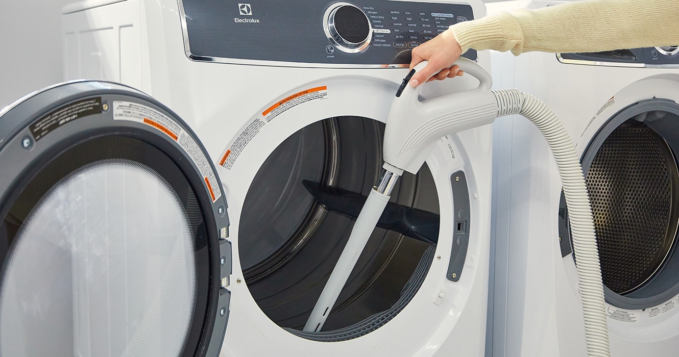 Person vacuuming inside a dryer 