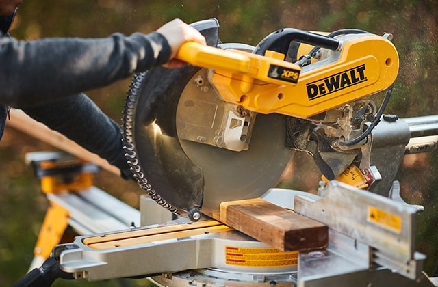 Person using a mitre saw to cut wood