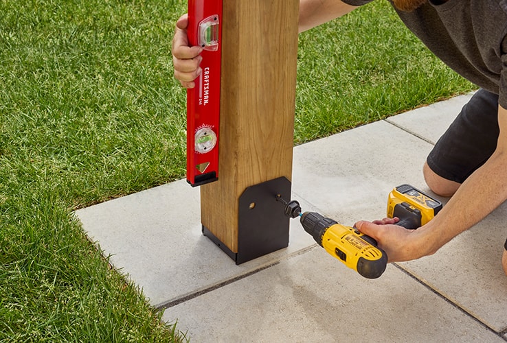 Personne installant les montants d’une pergola