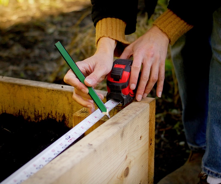 Femme mesurant un bac de jardinage