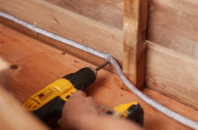 Personne installing LED light inside a wooden Halloween coffin