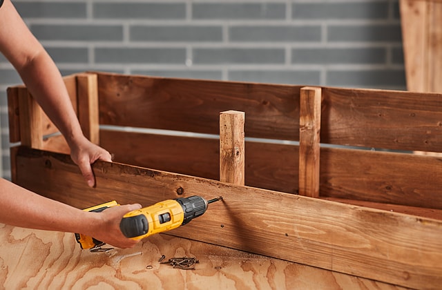 Person assembling a wooden Halloween coffin