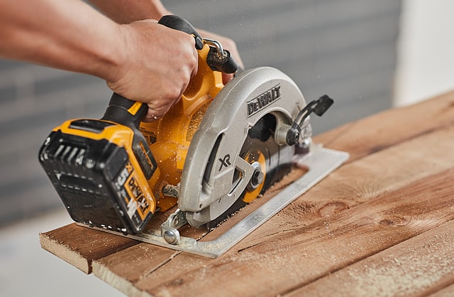 Person cutting wood with a circular saw