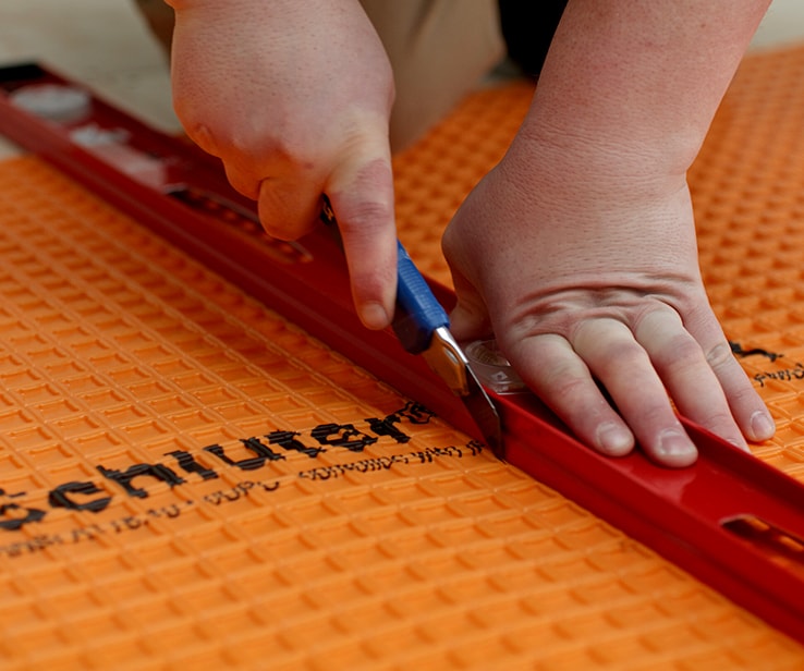 Personne coupant une membrane à plancher