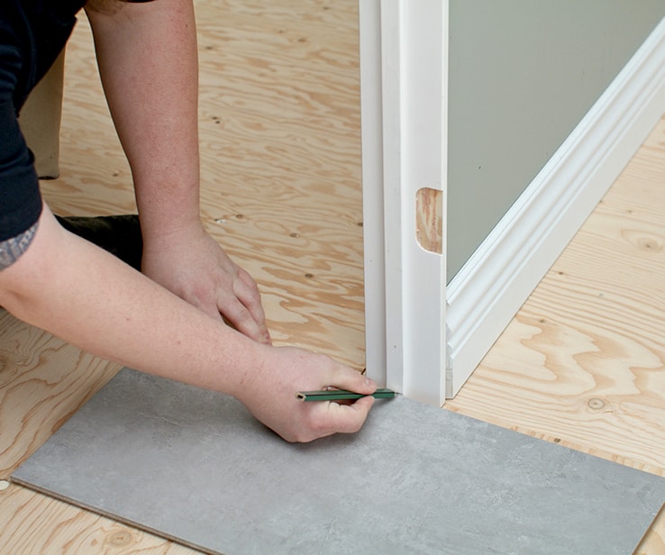 Person marking a line on a door casing