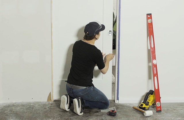 Personne qui installe la poignée d’une porte escamotable