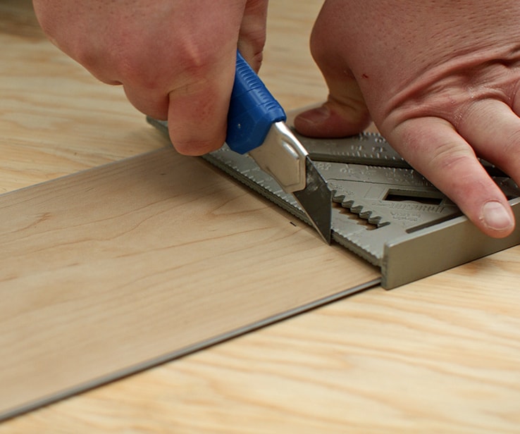 Person cutting a vinyl plank