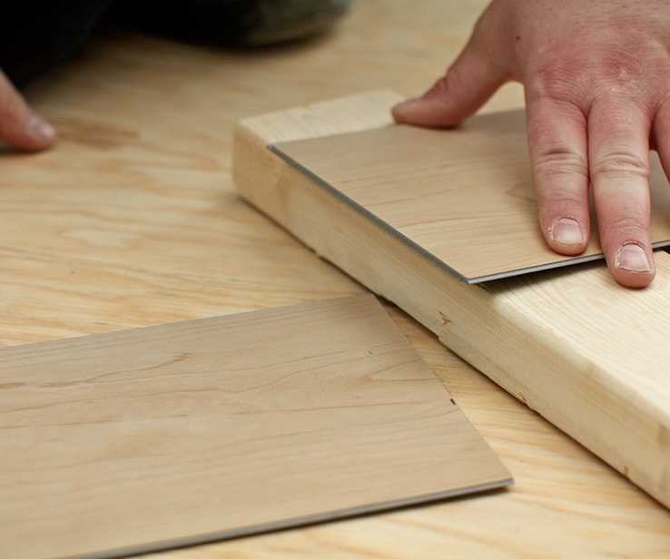 Person snapping a vinyl plank