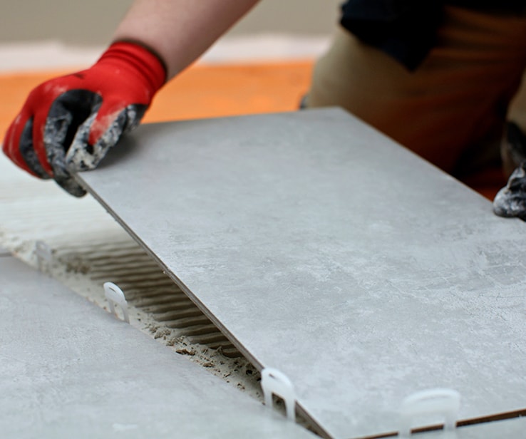 Person laying a ceramic tile