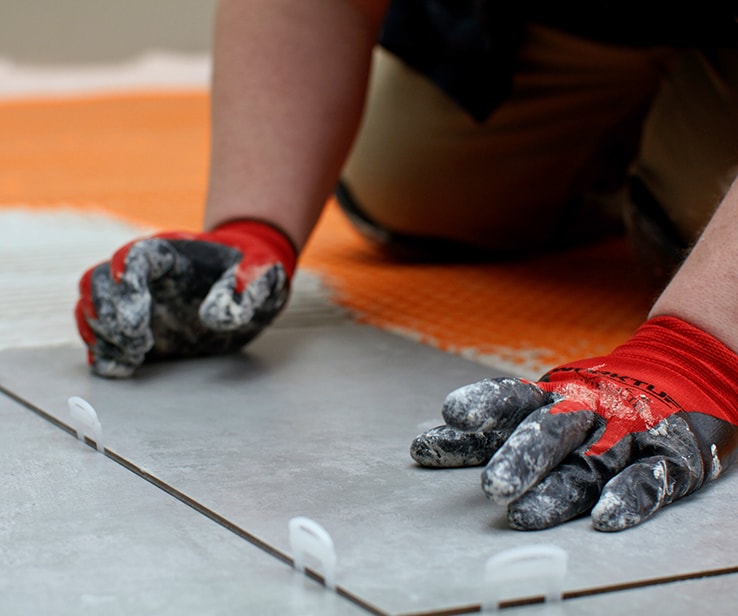 Person pressing down on a ceramic tile