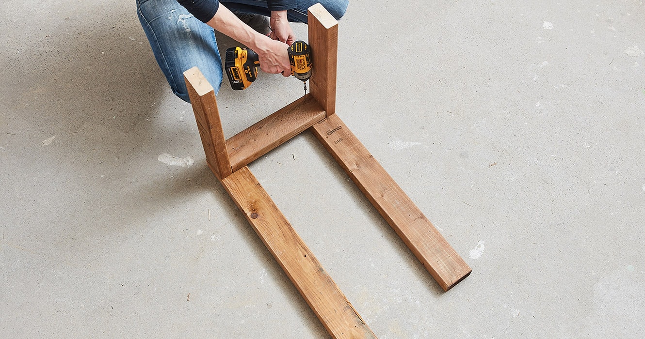 Femme assemblant une structure en bois