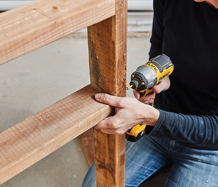 Femme assemblant une structure en bois