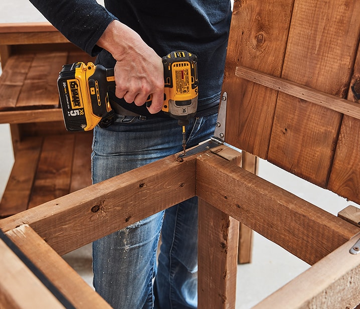 Femme assemblant une structure en bois