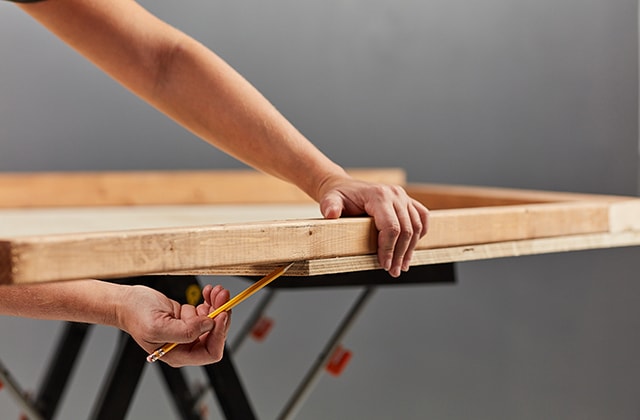 Person tracing an angle to create the roof of a house shape