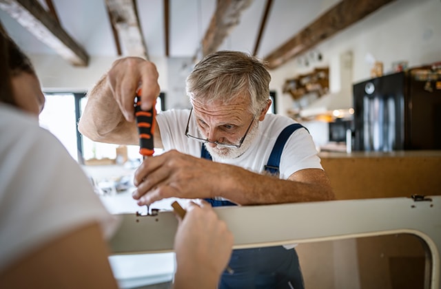 Homme démontant un meuble