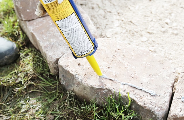 Ajouter de l’adhésif de construction sur les blocs de béton