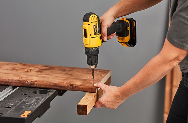 Person securing pieces of wood together