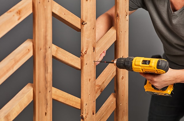 Person securing pieces of wood in a chevron pattern