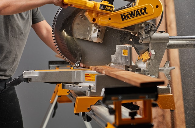 Person using a mitre saw to cut wood