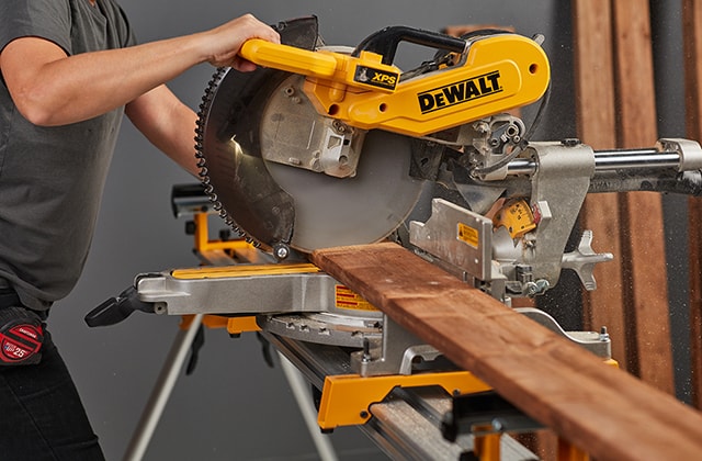 Person cutting large wooden planks