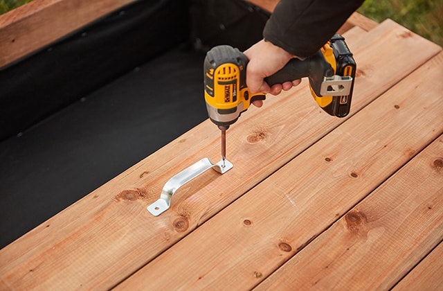 Personne fixant une poignée sur une porte en bois