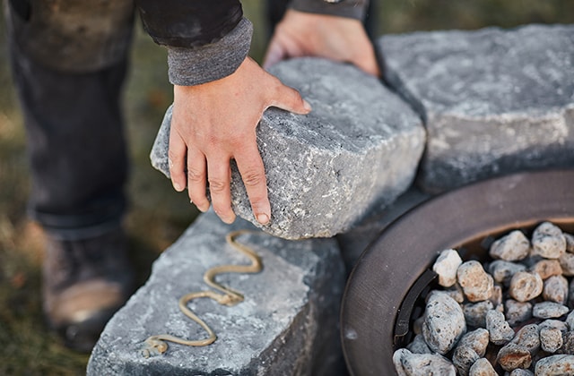 Personne collant une dernière rangée de blocs de béton