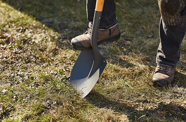 Person removing grass with a shovel