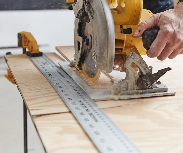 Person cutting plywood with a circular saw