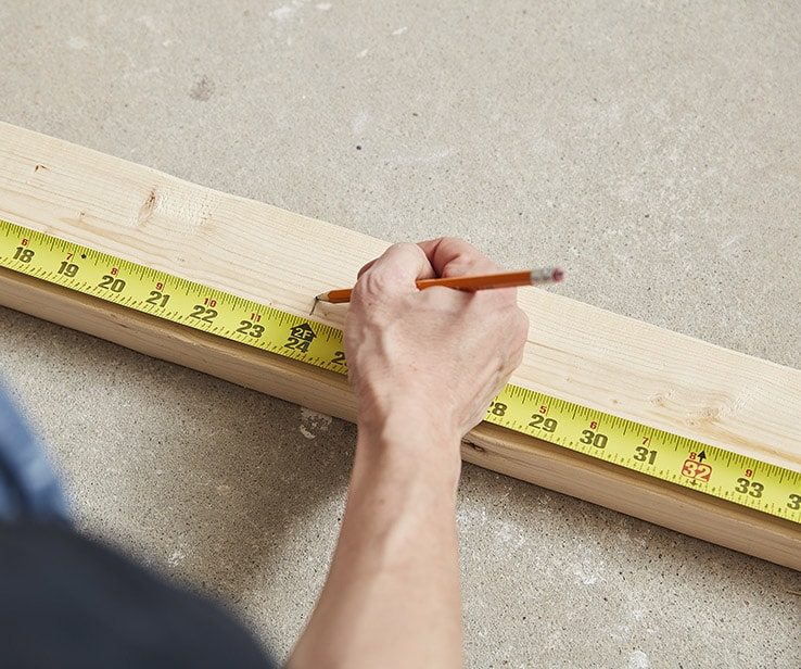 Person measuring a wooden plank