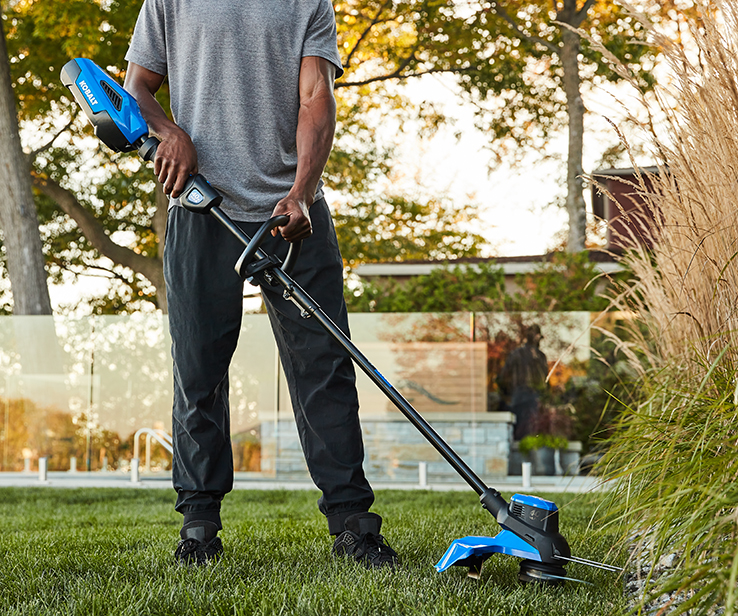 Homme utilisant un coupe-bordure de marque Kobalt