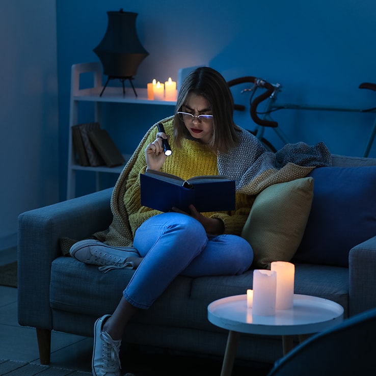 Jeune femme lisant pendant une panne de courant