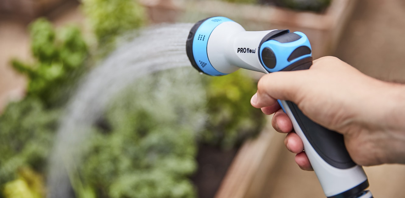 Person watering a garden with a hose