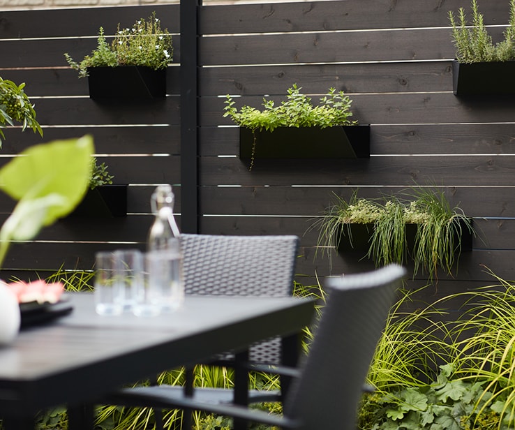 Flower boxes on a black privacy fence