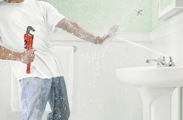 Man being sprayed by a bathroom faucet