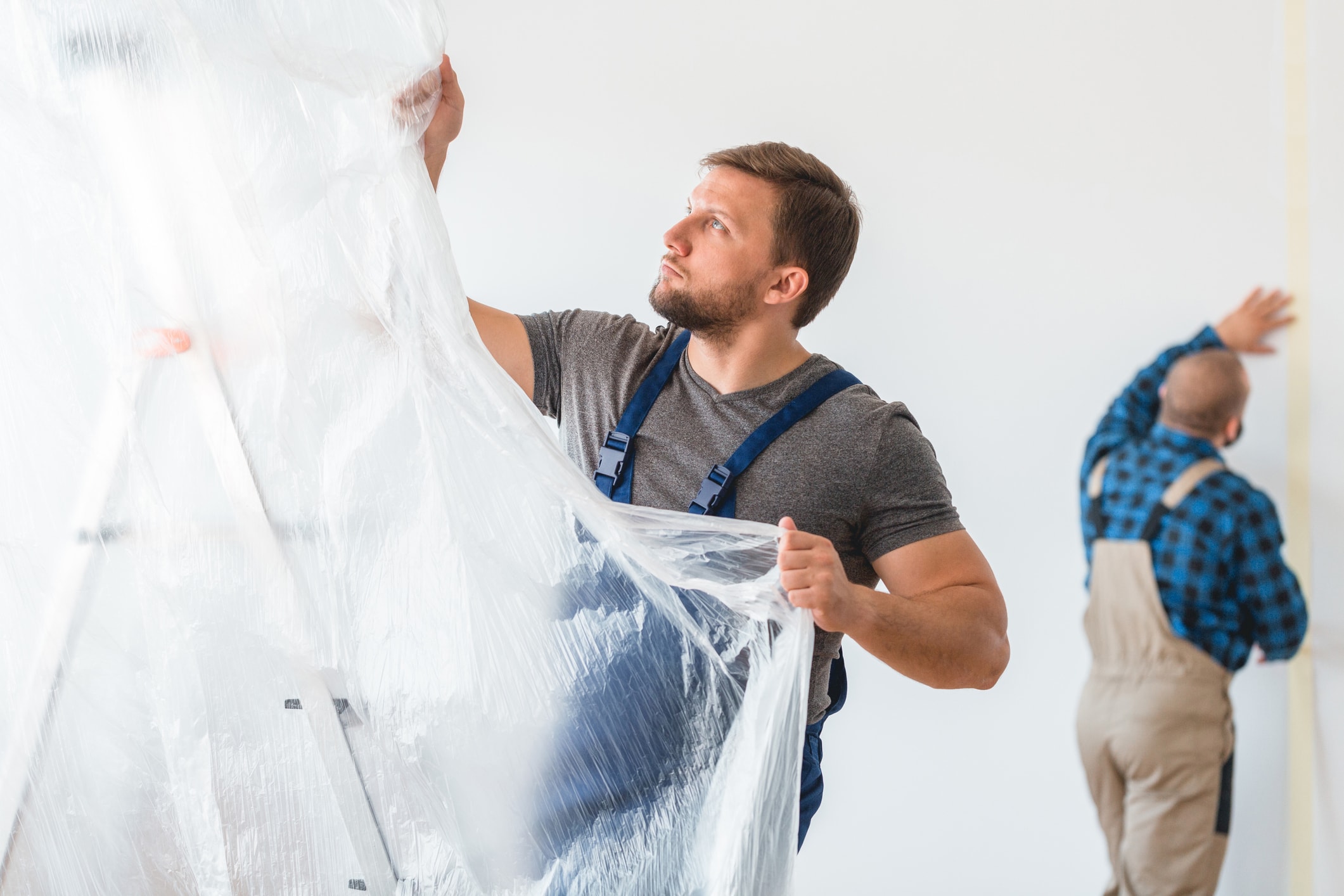 Man setting up a plastic drop sheet