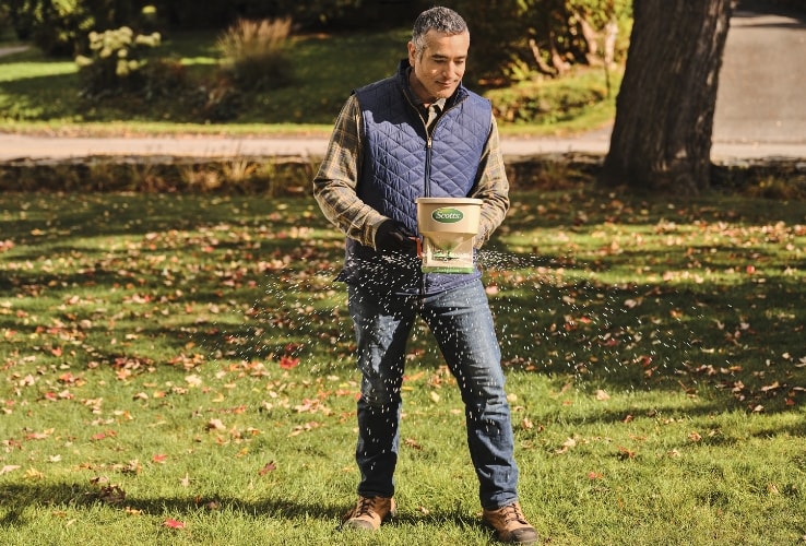 Person spreading lawn fertilizer