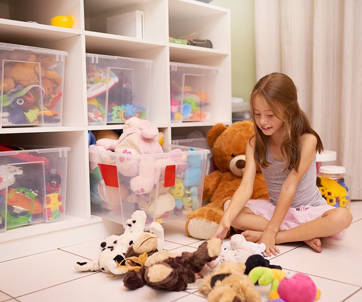 Petite fille avec des jouets bien rangés