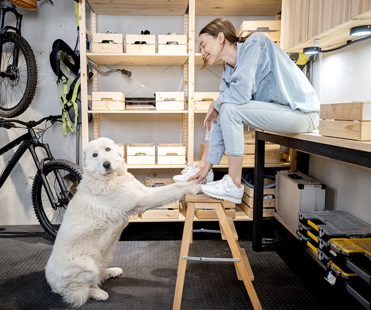 Jeune femme et son chien dans un garage