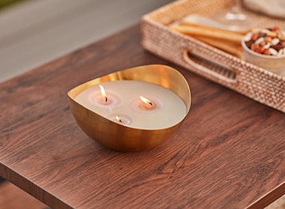 Brass bowl with a candle on a wooden outdoor table